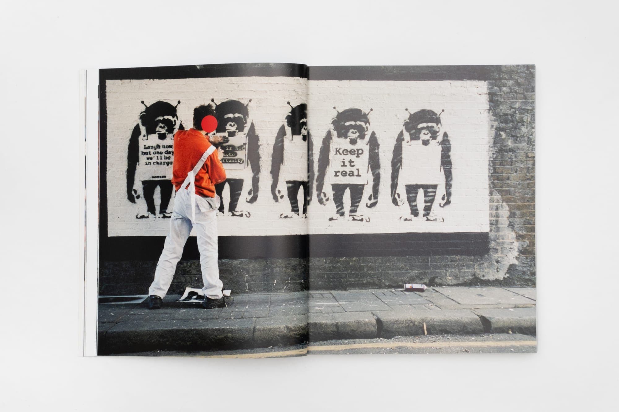 Spread — a row of stencilled figures, from Banksy Captured