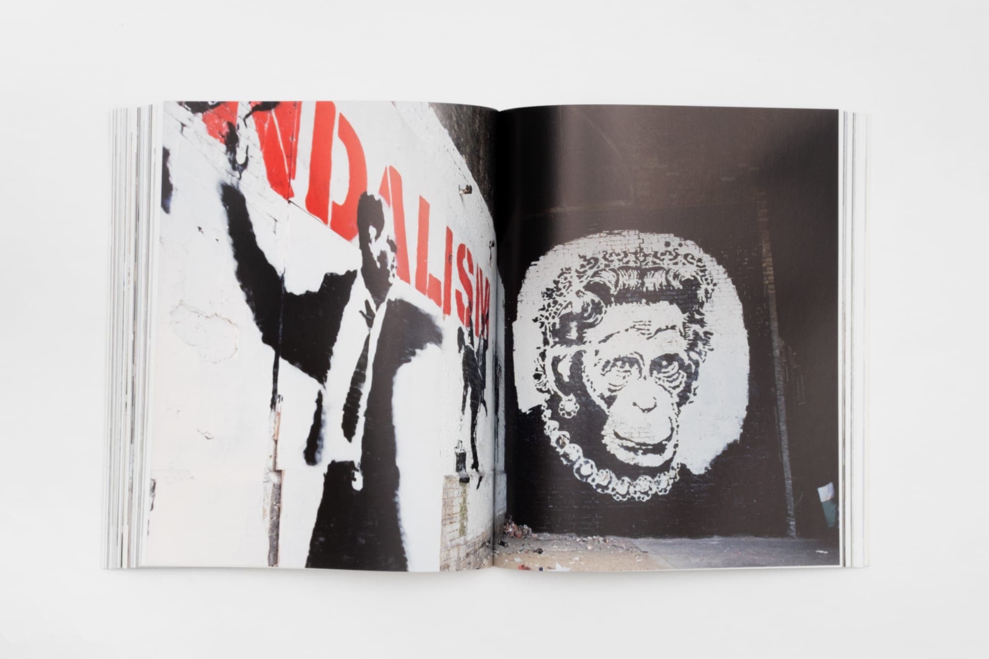 An interior spread printed against deep red, from Banksy Captured
